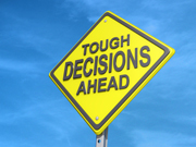 A road sign that says, "Tough Decisions Ahead". 