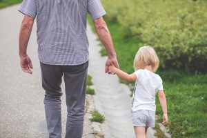 Papá sosteniendo la mano del niño mientras caminan