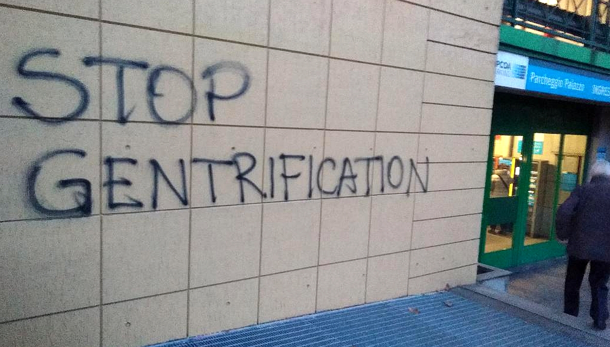 The words stop gentrification spray painted on a wall