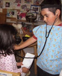 A boy pretending to listen to a girl's heartbeat with a stethoscope