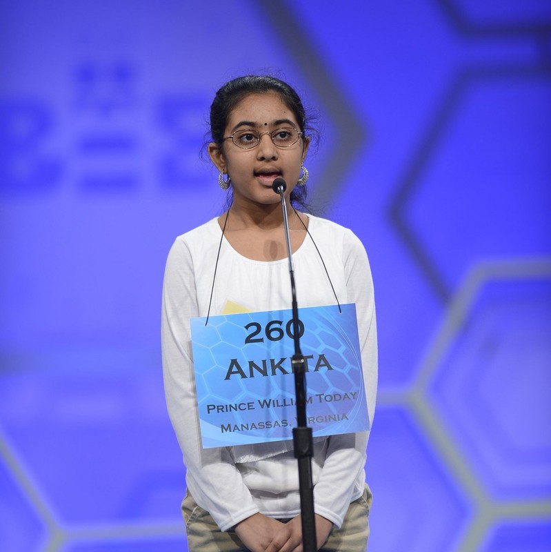 niño en un concurso de ortografía con letrero que dice 260 Ankita