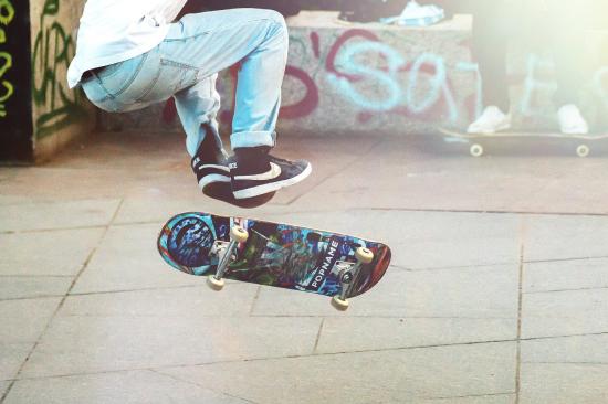 Skateboarder with feet hovering above suspended skateboard