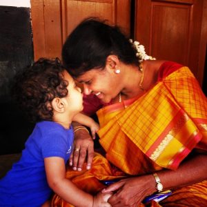Una madre sonríe ampliamente mientras nuca las narices con su hijo pequeño.