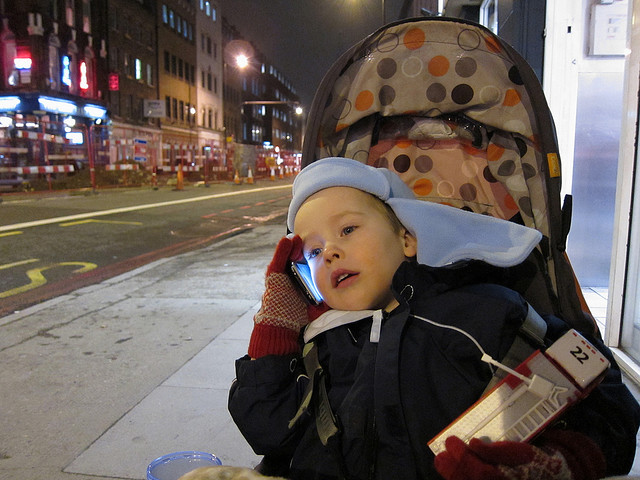 Un niño pequeño hablando por teléfono.