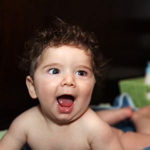 An infant showing a big open-mouthed grin." title="An infant showing a big open-mouthed grin.