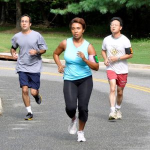 A group of joggers running through a park.