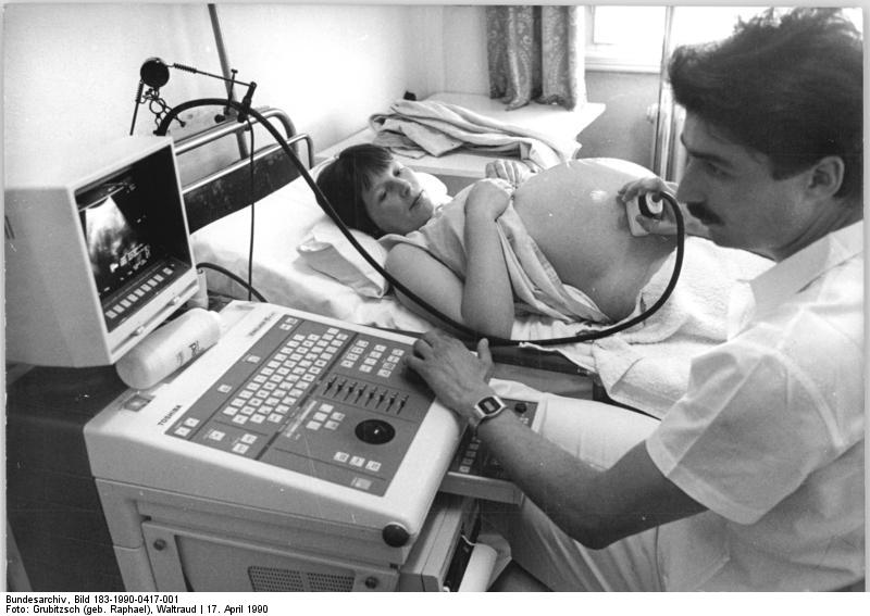 Un médico usa una ecografía para examinar a un feto.