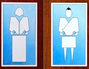 Restroom signs from the country of Bhutan display stylized representations of a woman and a man dressed in traditional clothes.