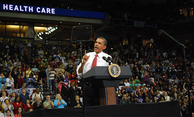 La photo est une photographie du président Barack Obama prononçant un discours sur la réforme des soins de santé.