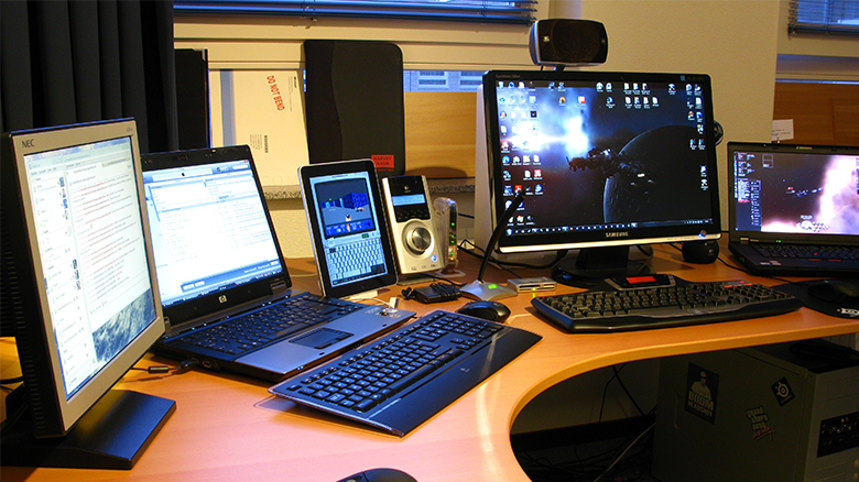 This image is a photograph of multiple laptop computers and other electronic devices.
