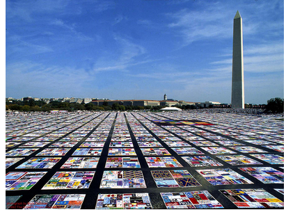 Photograph of the AIDS Quilt, an enormous community-created memorial for those who died from AIDS-related causes, in front of the Washington Monument in Washington, D.C.