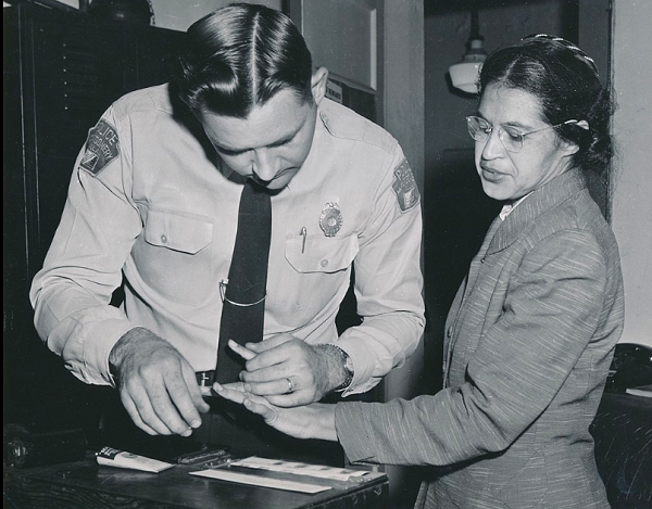 Black-and-white photograph of Rosa Parks being fingerprinted by Deputy Sheriff D.H. Lackey after being arrested as a leader of the Montgomery bus boycott, Montgomery, Alabama, February 1956.