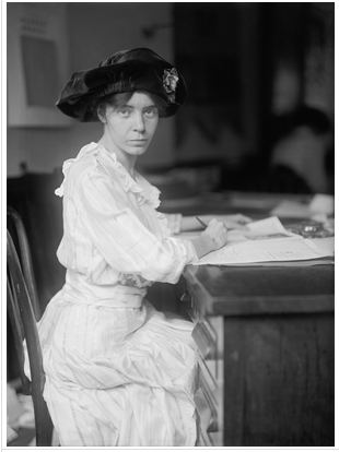 Black-and-white photograph of Alice Paul at her desk, taken by Harris Ewing in 1915.