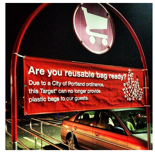 Photograph of a shopping cart return in parking lot of a Target in Portland, Oregon. A banner hanging from the frame of the return states "Are you reusable bag ready? Due to a City of Portland, ordinance, this Target can no longer provide plastic bags to its guests." Photograph taken by Tony Webster on April 22, 2012.