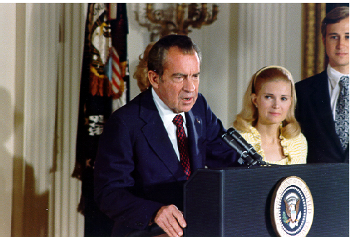 Color photograph of Richard Nixon making his farewell speech to the White House staff on August 8, 1974, with his daughter Julie and son-in-law Richard Eisenhower looking on.