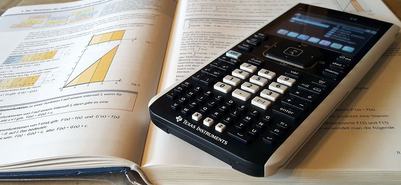 Calculator laying on open textbook
