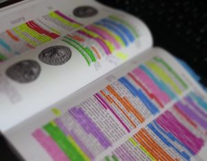open textbook with most of the text highlighted in various colors