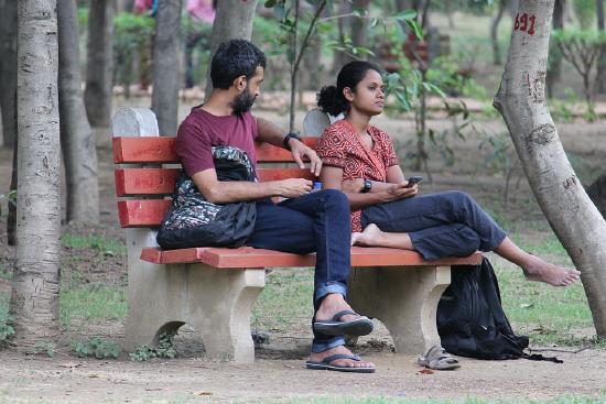 Couple sitting on a bench, arguing.
