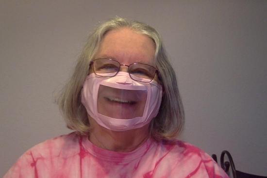 A person wearing a face mask with a clear mouth window
