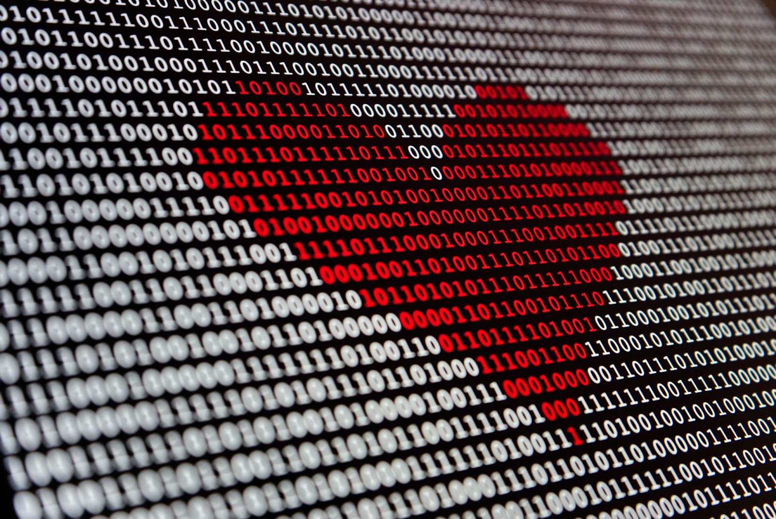 Imagen digital de un corazón rodeado de código binario en una pantalla de computadora