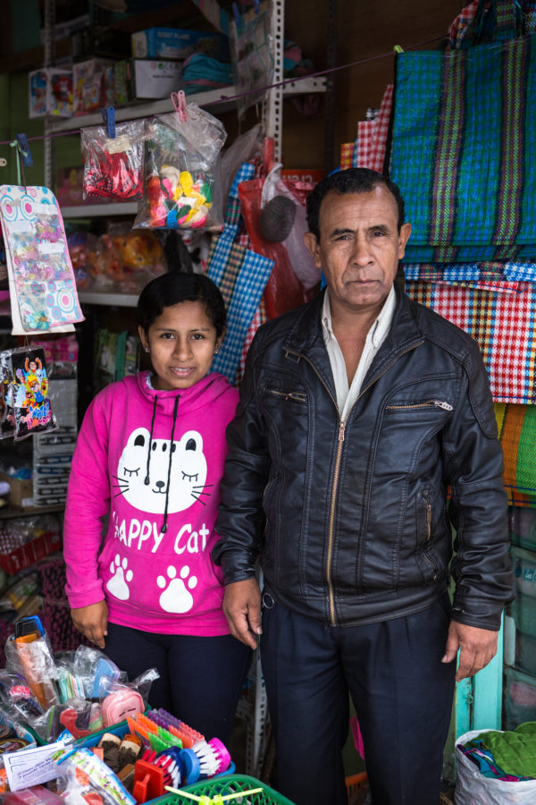 Padre e hijo vendiendo artículos en un mercado local en Lima Perú