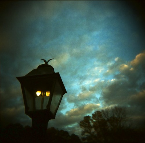 An old-fashioned street light against a night sky.