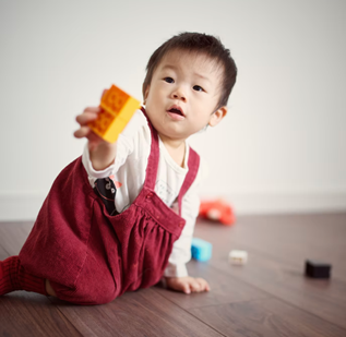 Niño sosteniendo un objeto con una mano mientras usa la otra mano para equilibrar
