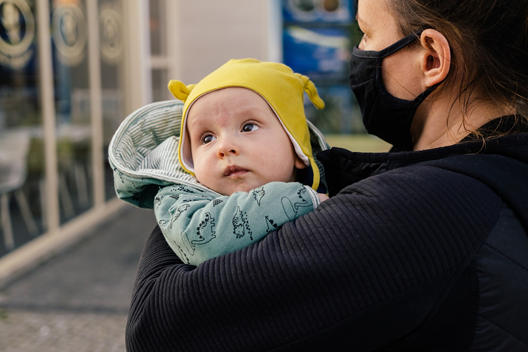 Cuidador que usa mascarilla mientras sostiene a un bebé