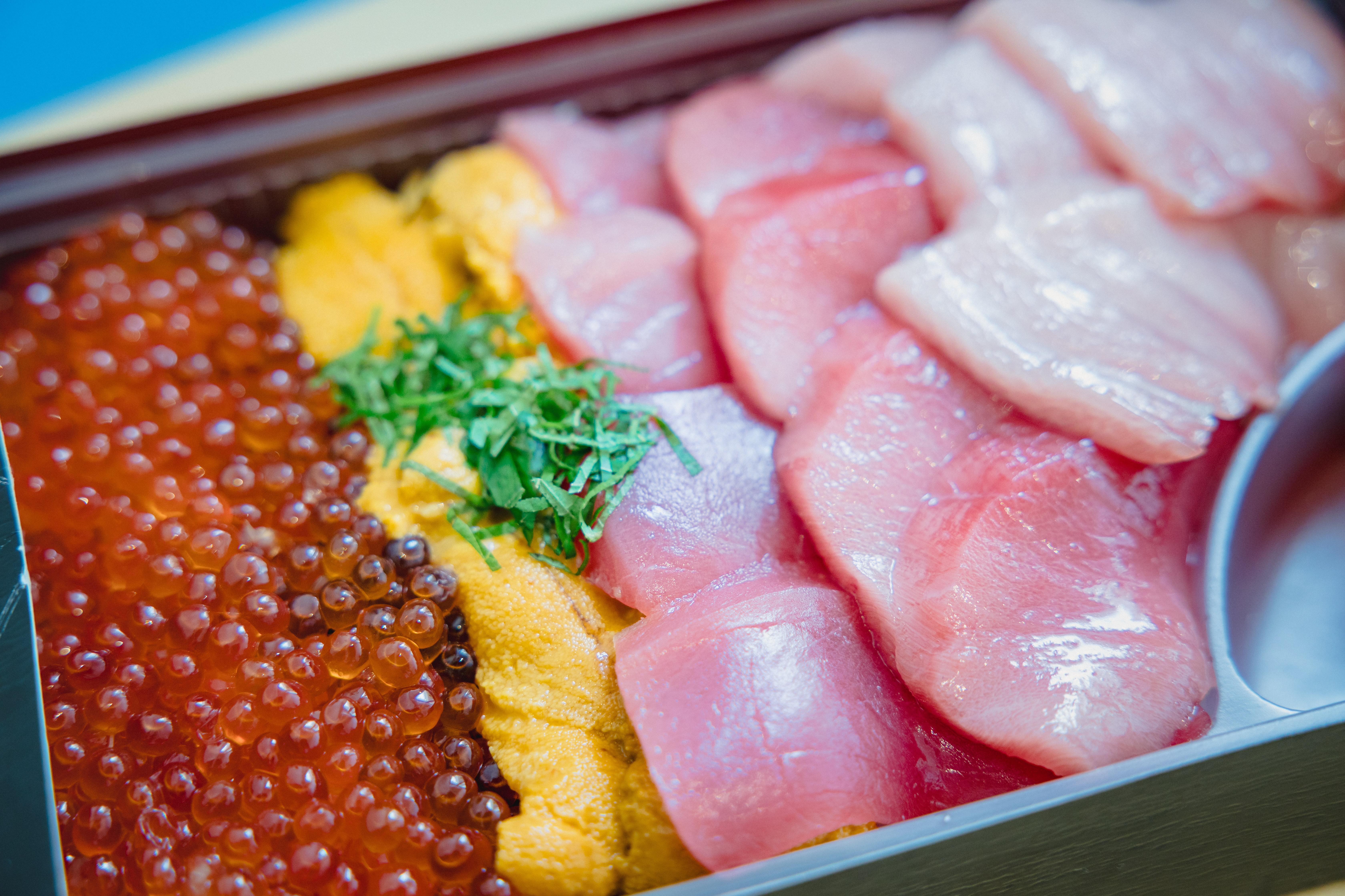 Un plato de huevos de pescado y rebanadas de pescado crudo - una delicia para el amante del sushi.
