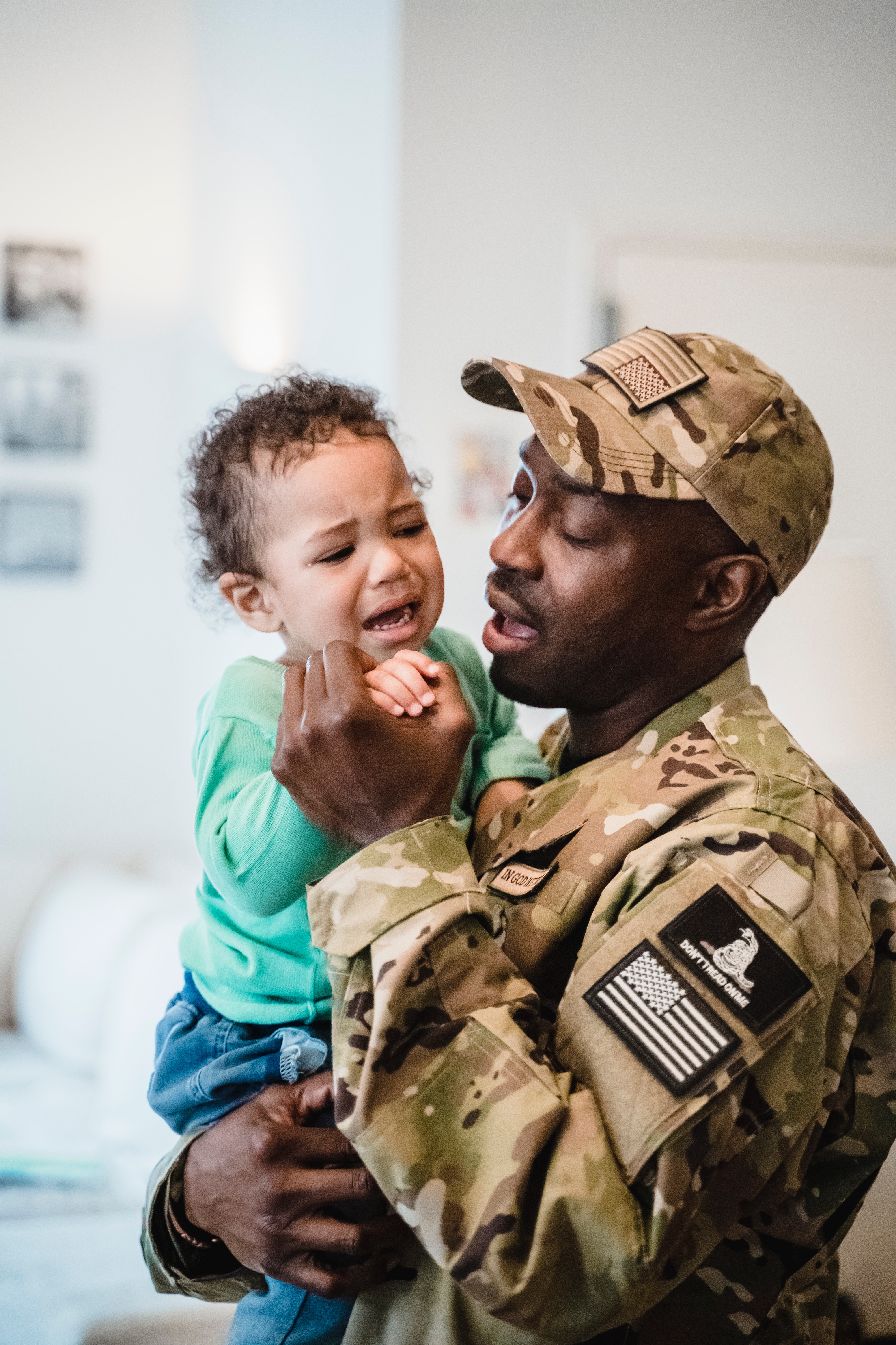 man in uniform holding crying baby