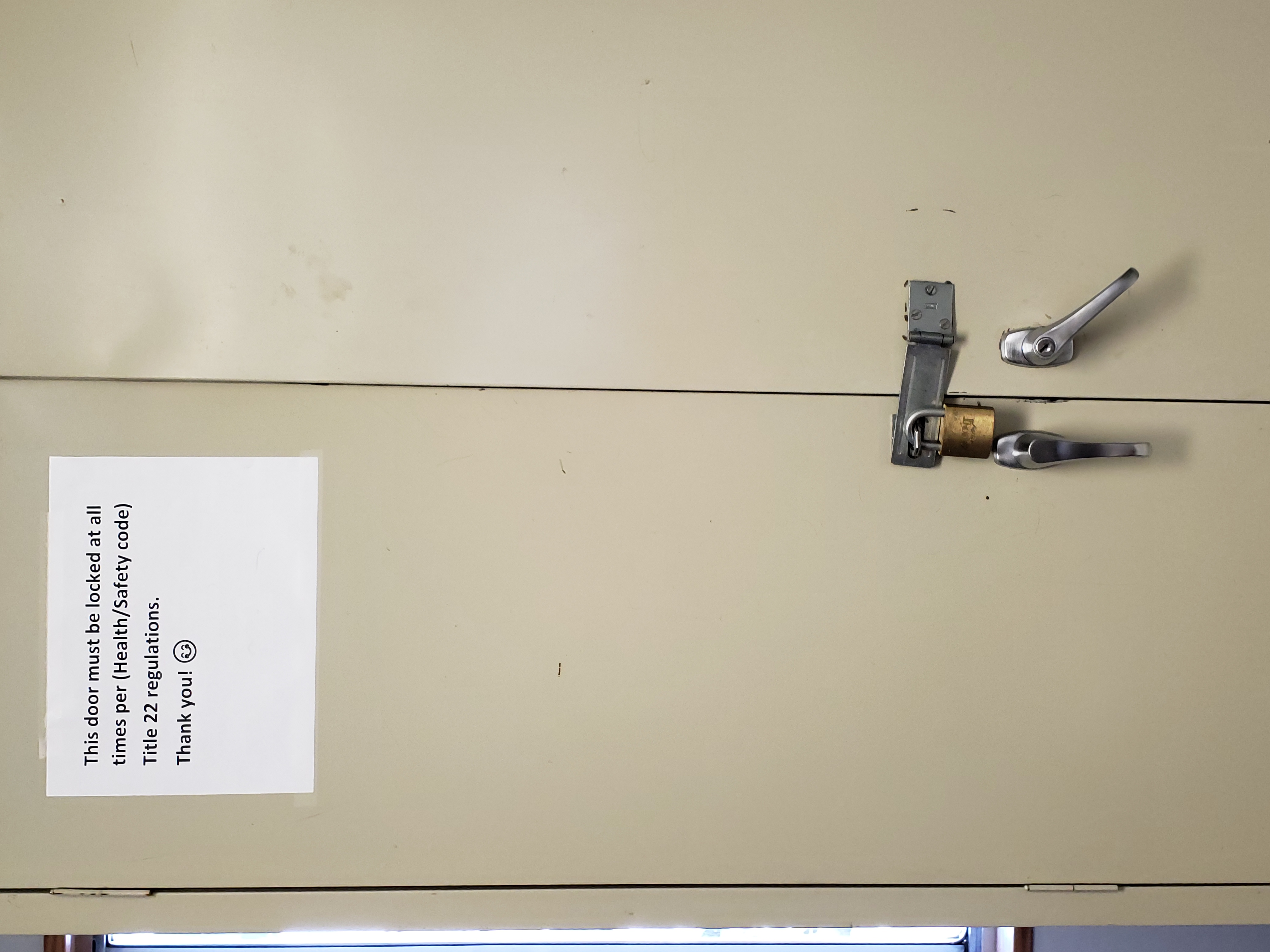 Cabinet with locked door and sign reading "this door must be locked at all times per (Health/safety code) title 22 regulations. Thank you! Smiley face. 