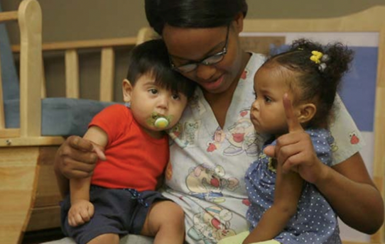 Caregiving holding two infants
