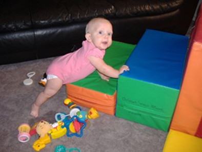 Infant crawling up large foam blocks