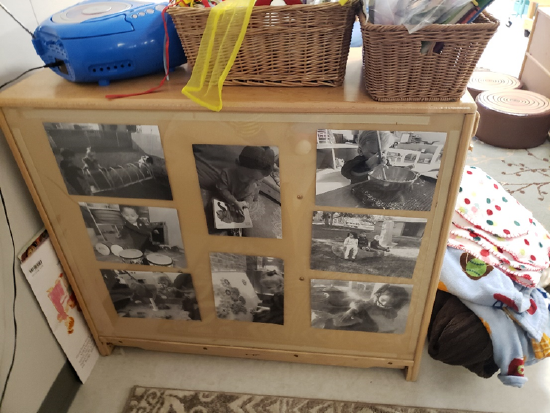 the back of a shelf with printed pictures of toddlers engaged in activities. 