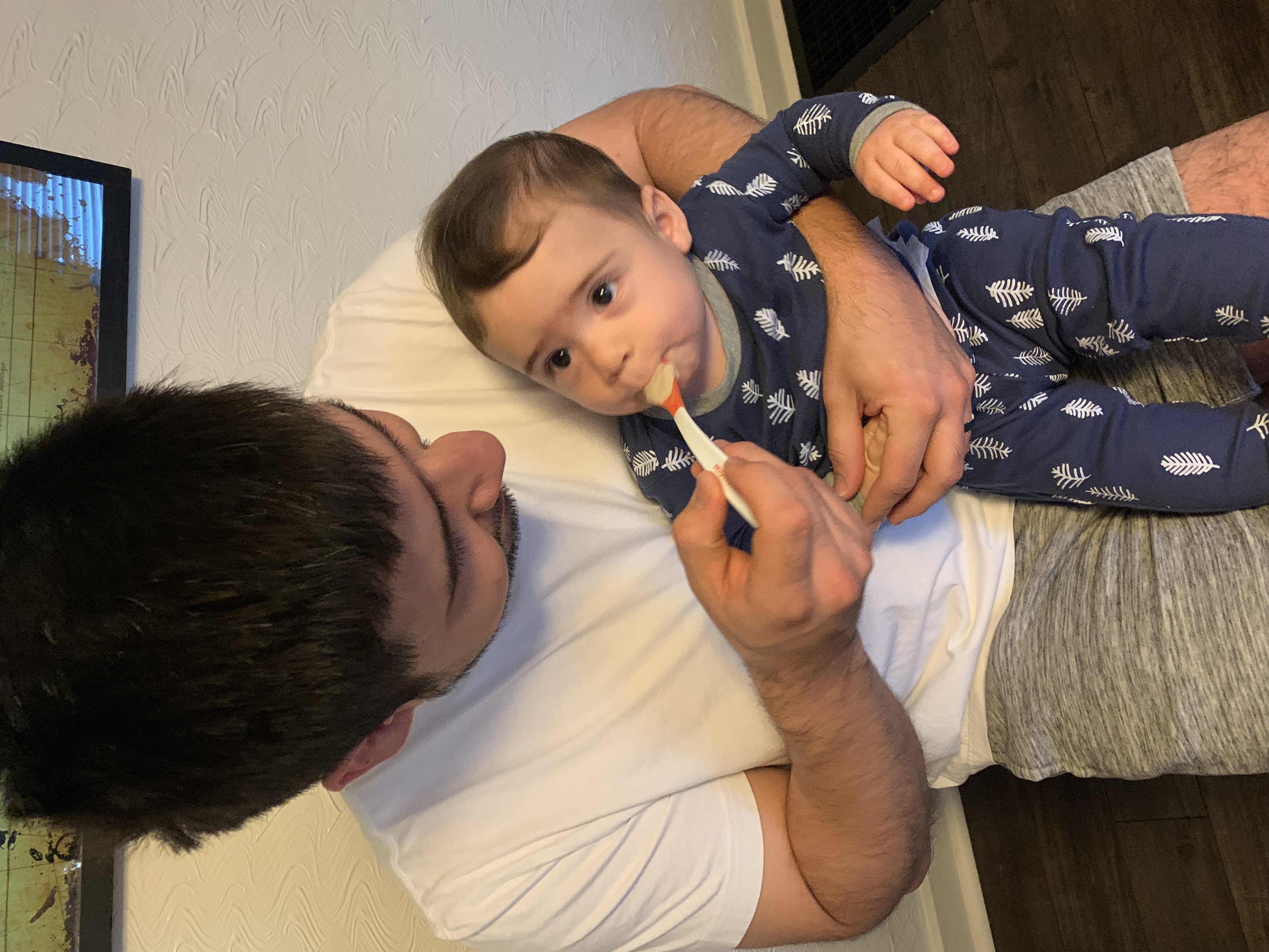 Caregiver spoon feeding infant in lap