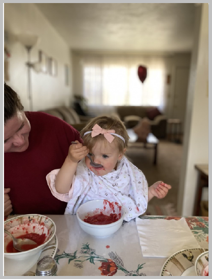Toddler eating at table with caregiver