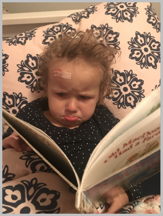 Infant with tears looking at book