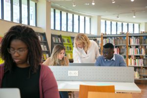 Lady helping students in library