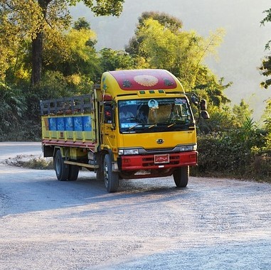 An unconventionally colorful transport truck driving up a hill 