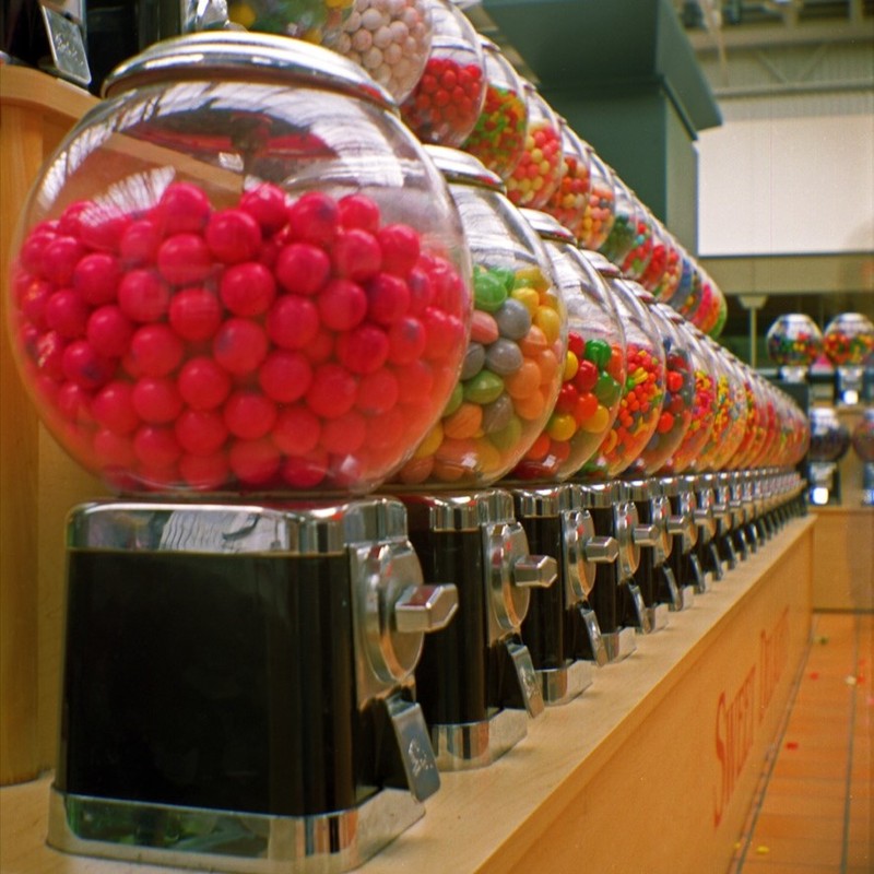 A long row of coin-operated gumball machines.
