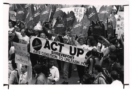 Black and white photo of ACT UP protestors marching and holding signs at the NIH